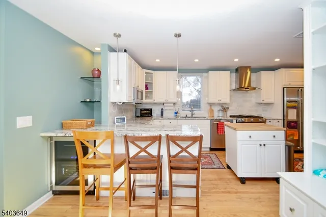 a kitchen with stainless steel appliances kitchen island granite countertop a stove a sink and a refrigerator