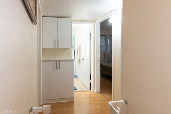 a view of a kitchen with white cabinets and wooden floor