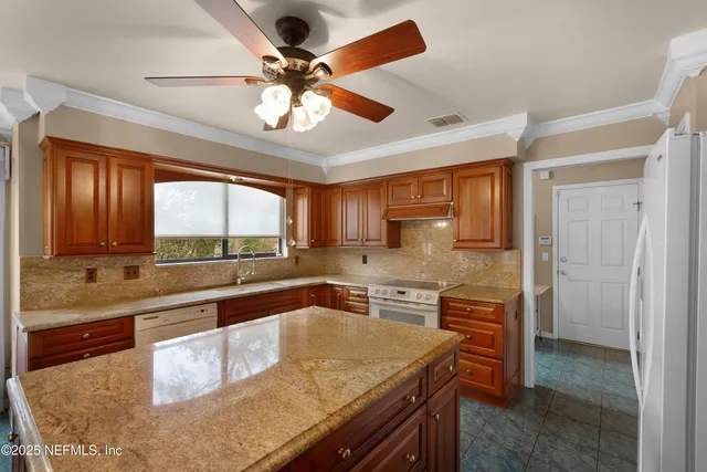 a kitchen with stainless steel appliances granite countertop sink stove and refrigerator