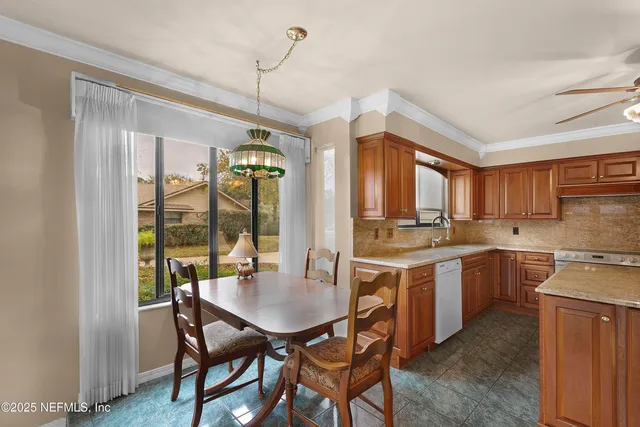 a kitchen with a stove a sink dishwasher a dining table and chairs with wooden floor