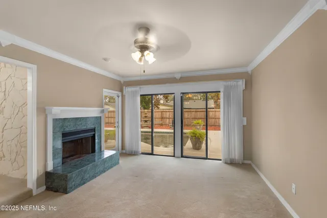 a view of an empty room with a fireplace and a window