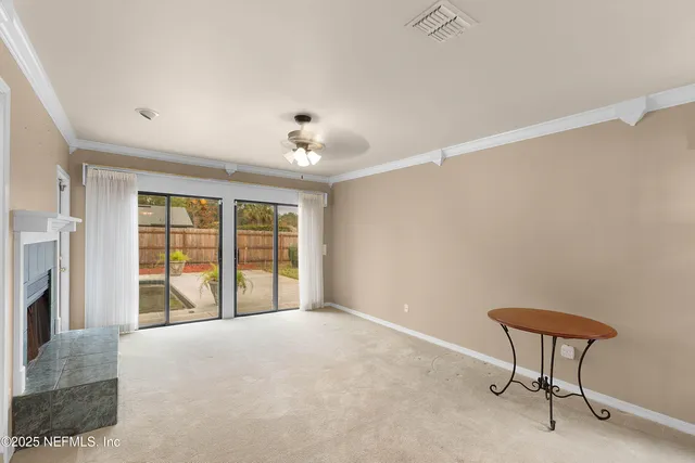 a view of an empty room with a fireplace and a window