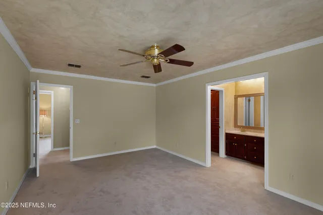 a view of an empty room and a ceiling fan
