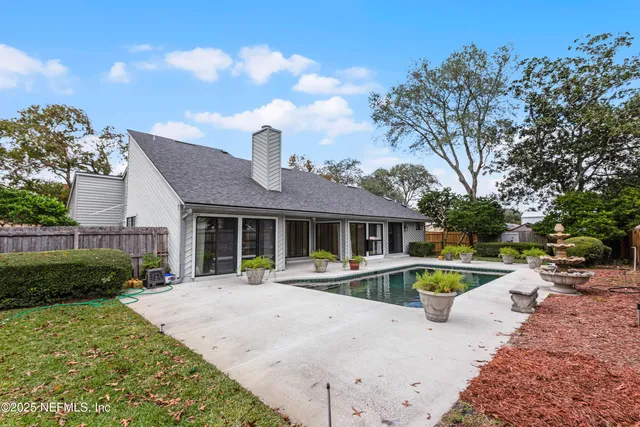 a view of a house with backyard and sitting area