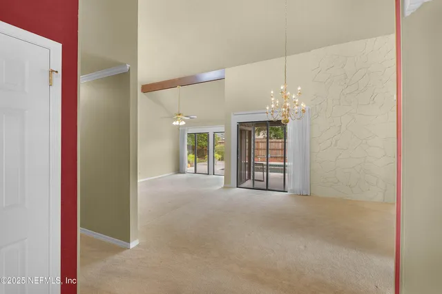 a view of a big room with windows and chandelier