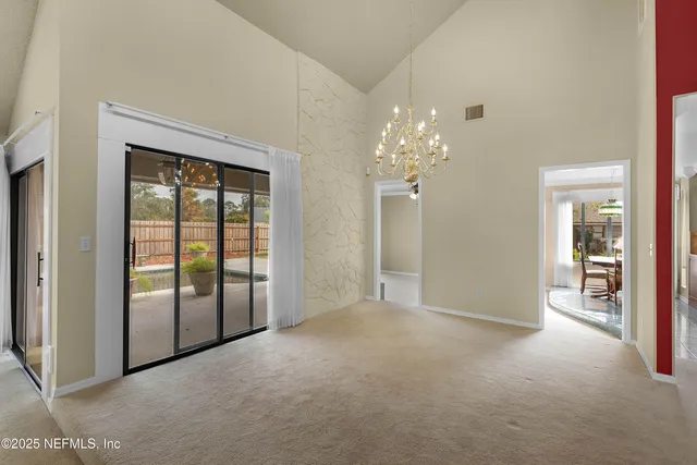 a view of a big room with windows and chandelier