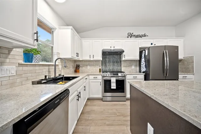 a kitchen with stainless steel appliances granite countertop a sink stove and refrigerator