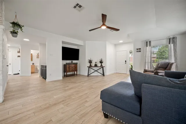 a living room with furniture and a wooden floor