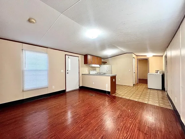 a view of a big room with wooden floor and windows