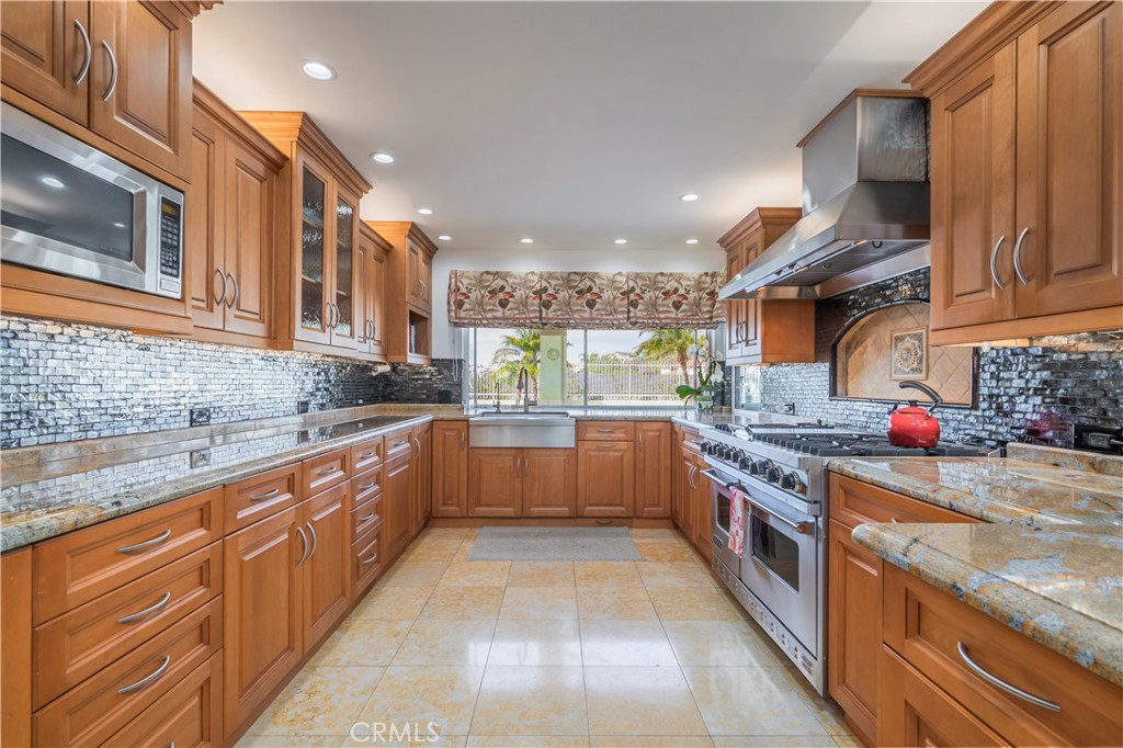 8213 Seranata Drive Whittier, CA 90603 - Photo 12 of 64 a large kitchen with stainless steel appliances granite countertop a stove a sink and a microwave