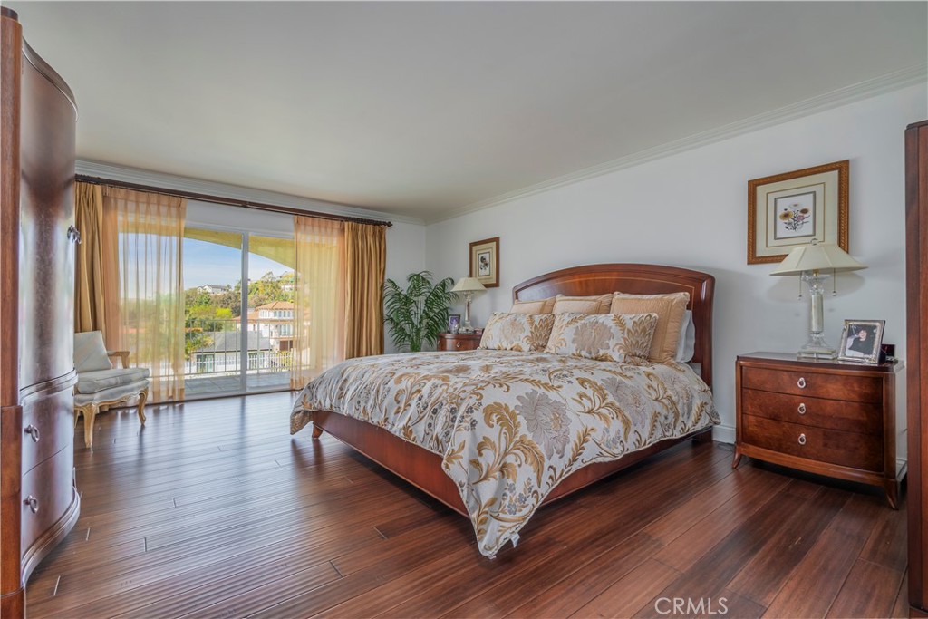 8213 Seranata Drive Whittier, CA 90603 - Photo 30 of 64 a bedroom with a large bed and a wooden floor