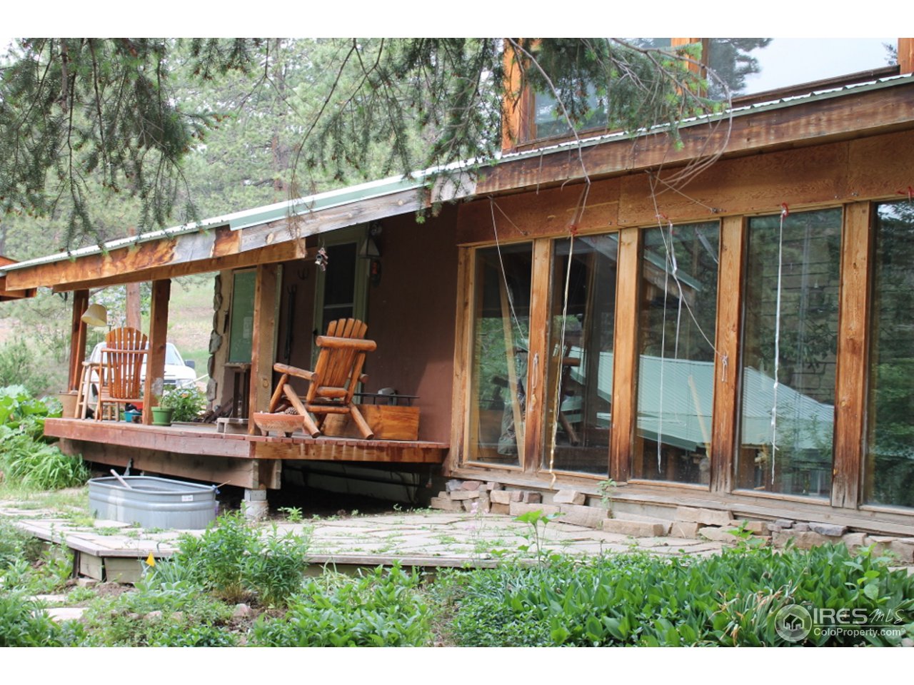 11220 Rist Canyon Road Bellvue, CO 80512 - Photo 7 of 25 a backyard of a house with wooden floor and outdoor seating