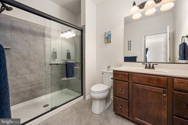 a bathroom with a sink a toilet a mirror and shower