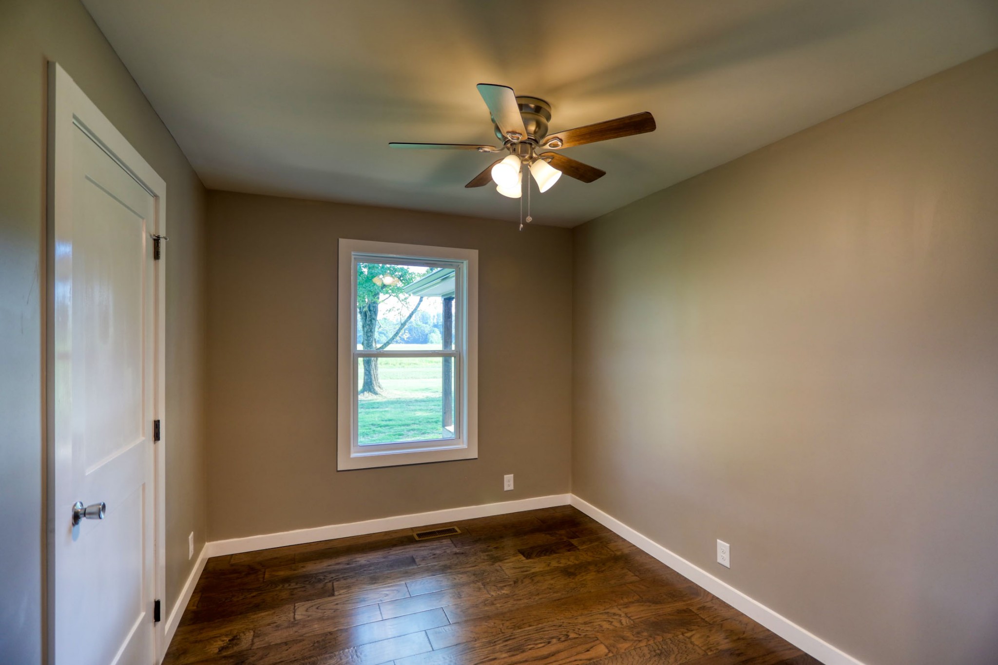 120 Vantrease Road Cottontown, TN 37048 - Photo 20 of 31 an empty room with wooden floor fan and windows