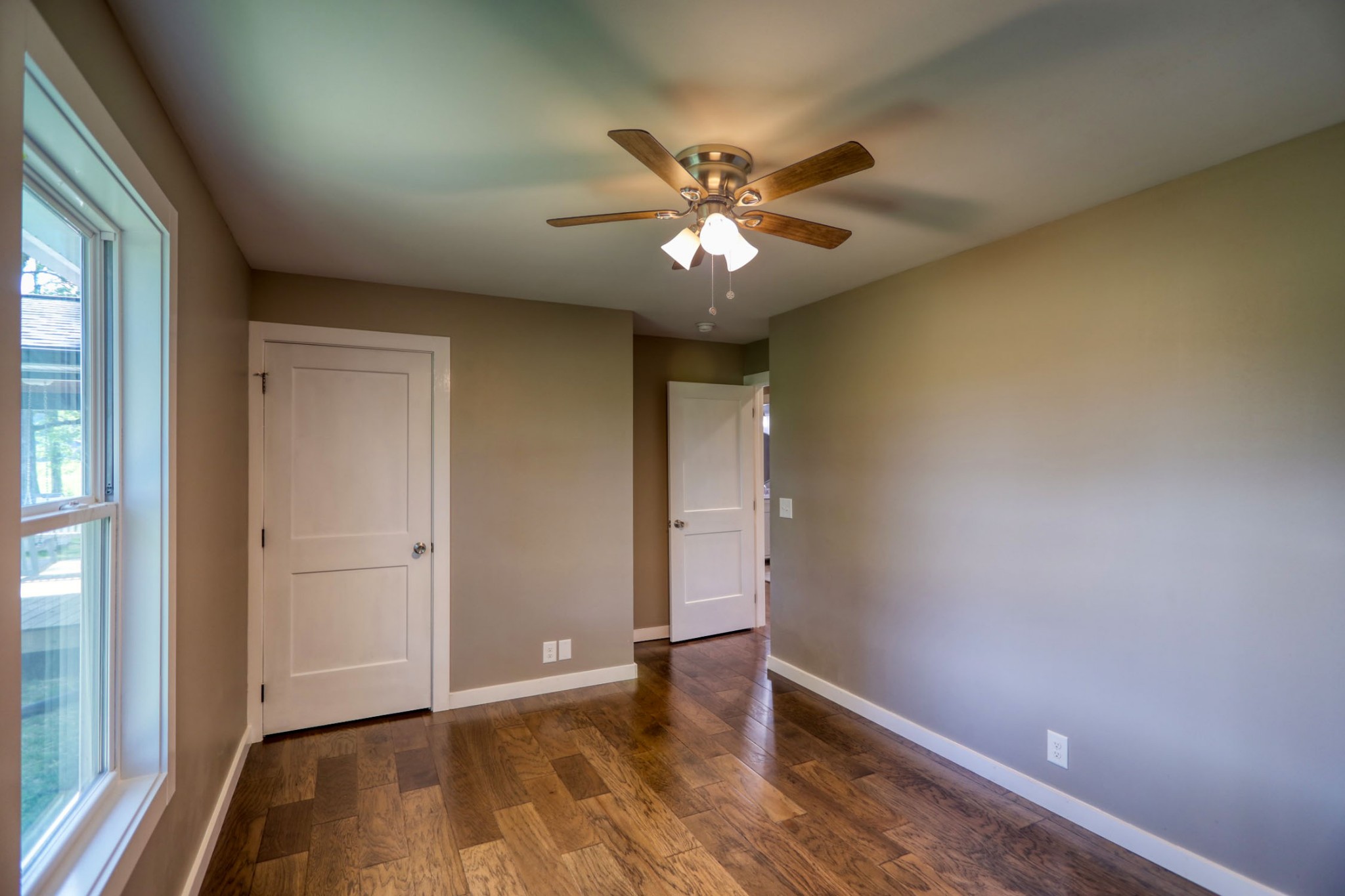 120 Vantrease Road Cottontown, TN 37048 - Photo 24 of 31 an empty room with wooden floor chandelier fan and windows