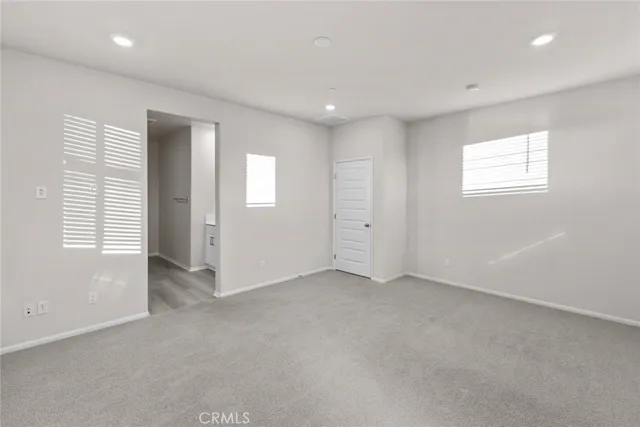 an empty room with windows and closet