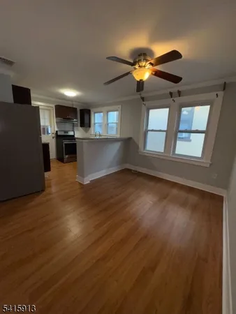a view of a living room with hardwood floor and windows