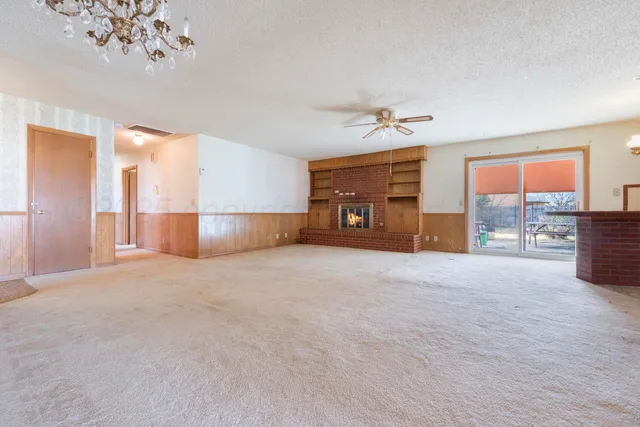 a view of empty room with a fireplace and fan