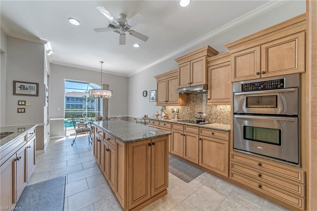 2004 Timarron Way Naples, FL 34109 - Photo 15 of 30 a kitchen with stainless steel appliances granite countertop a stove top oven a sink dishwasher and a refrigerator with wooden cabinets