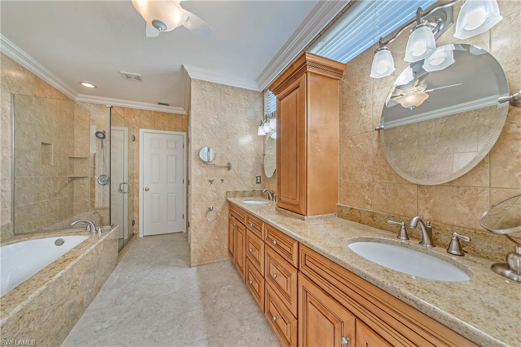2004 Timarron Way Naples, FL 34109 - Photo 23 of 30 a bathroom with a double vanity sink double mirror and shower