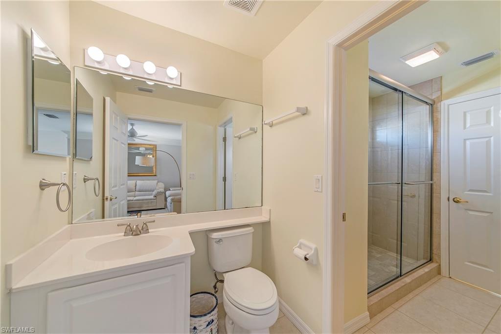 2004 Timarron Way Naples, FL 34109 - Photo 26 of 30 a bathroom with a toilet a sink a mirror a vanity and shower