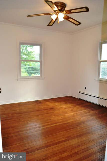4227 Round Hill Road Silver Spring, MD 20906 - Photo 14 of 24 an empty room with wooden floor fan and windows
