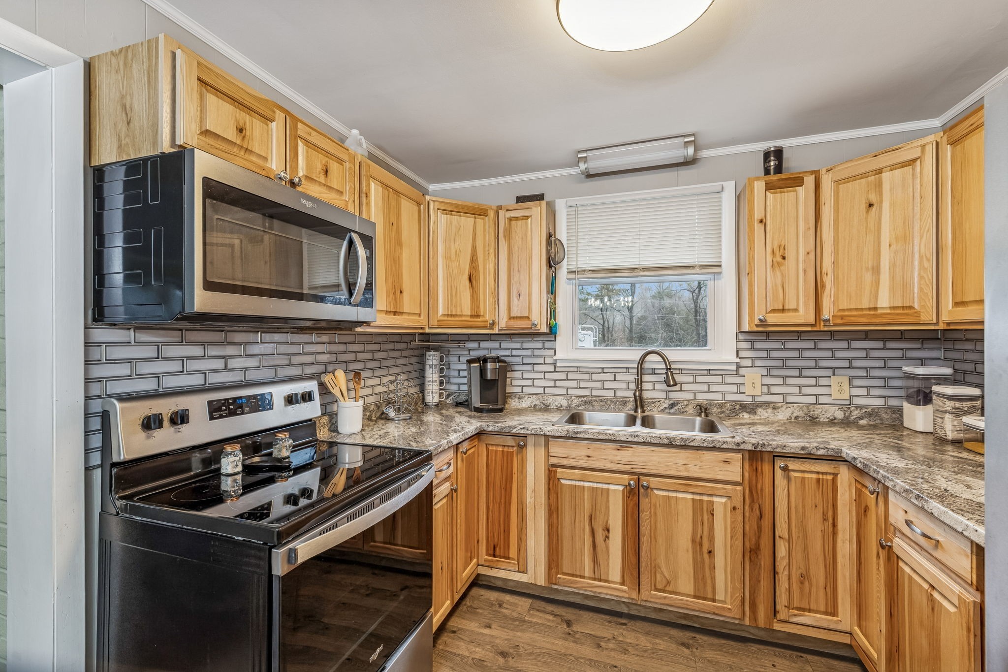 8871 Pinewood Road Lyles, TN 37098 - Photo 11 of 35 a kitchen with stainless steel appliances a stove sink microwave and cabinets