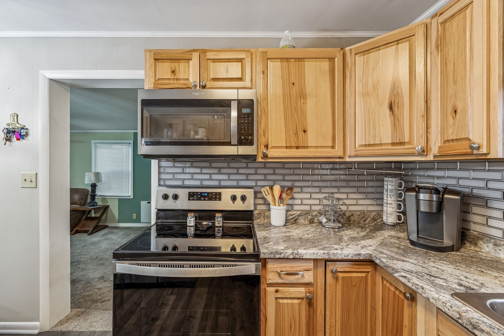8871 Pinewood Road Lyles, TN 37098 - Photo 10 of 35 a kitchen with granite countertop a stove a sink and a microwave