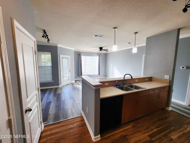 a kitchen with stainless steel appliances granite countertop a sink a stove and a wooden floor
