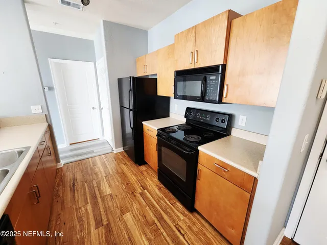 a kitchen with stainless steel appliances a stove microwave and refrigerator