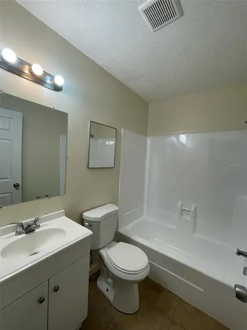 a bathroom with a shower a toilet a sink and a mirror
