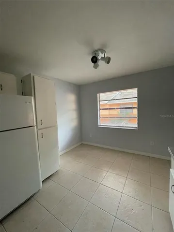 an empty room with a ceiling fan and carpet