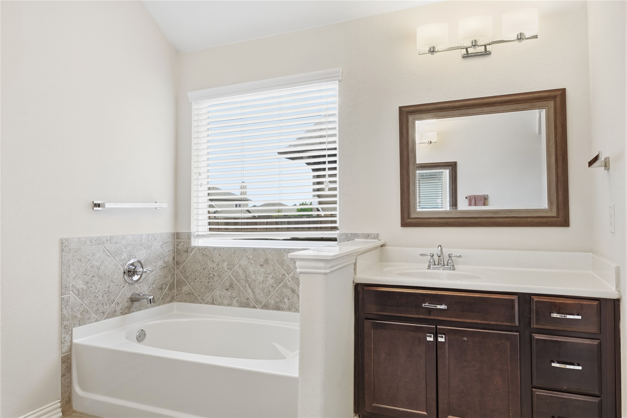 486 Pond View Pass Buda, TX 78610 - Photo 33 of 39 Built-in bathtub with tiled surround featuring a window with blinds