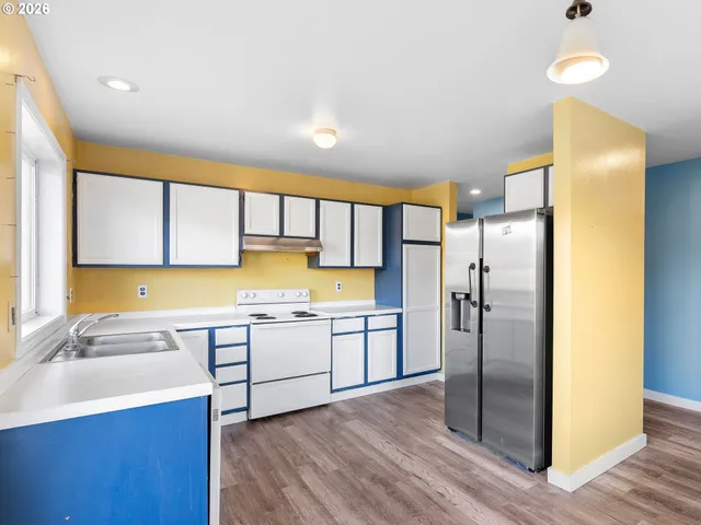 a kitchen with a sink appliances cabinets and a counter top space