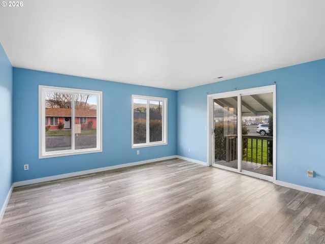 a view of an empty room with glass door and balcony