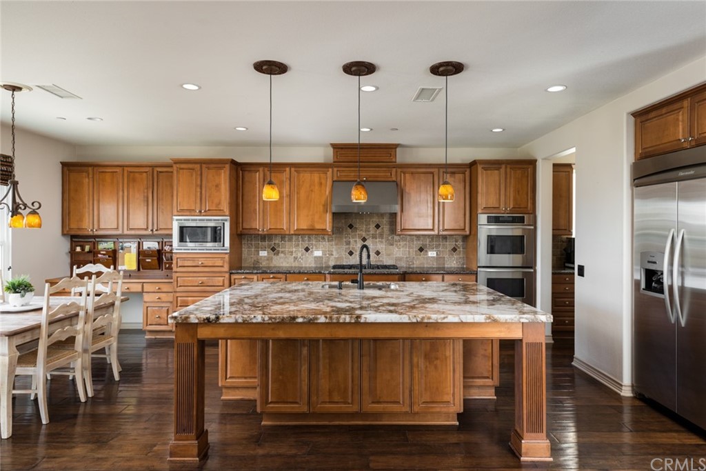 8 Kane Lane Ladera Ranch, CA 92694 - Photo 8 of 29 a kitchen with stainless steel appliances granite countertop wooden floors and wooden cabinets