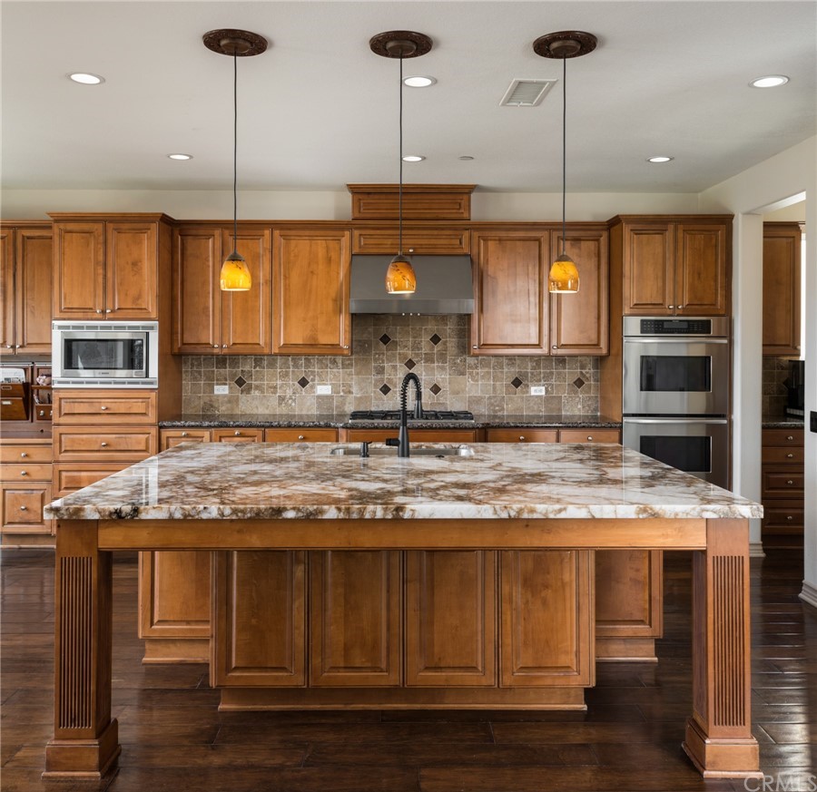 8 Kane Lane Ladera Ranch, CA 92694 - Photo 9 of 29 a kitchen with kitchen island granite countertop a sink a counter space appliances and cabinets