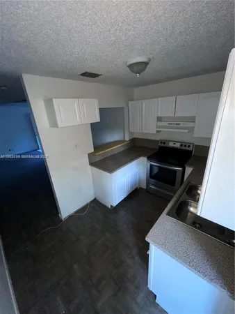 a kitchen with sink refrigerator and cabinets
