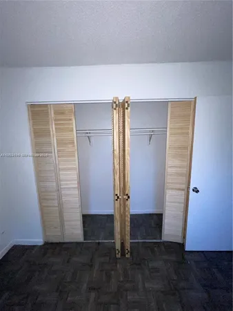 an empty room with wooden floor and cabinet