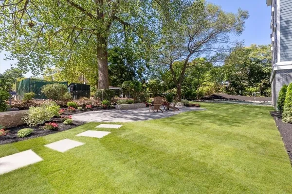 a view of swimming pool with lawn chairs and plants