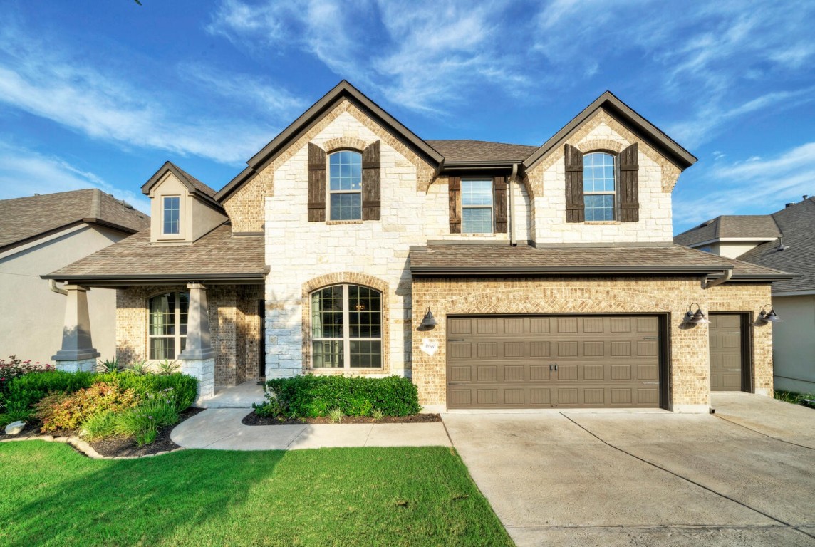a front view of a house with a yard and garage