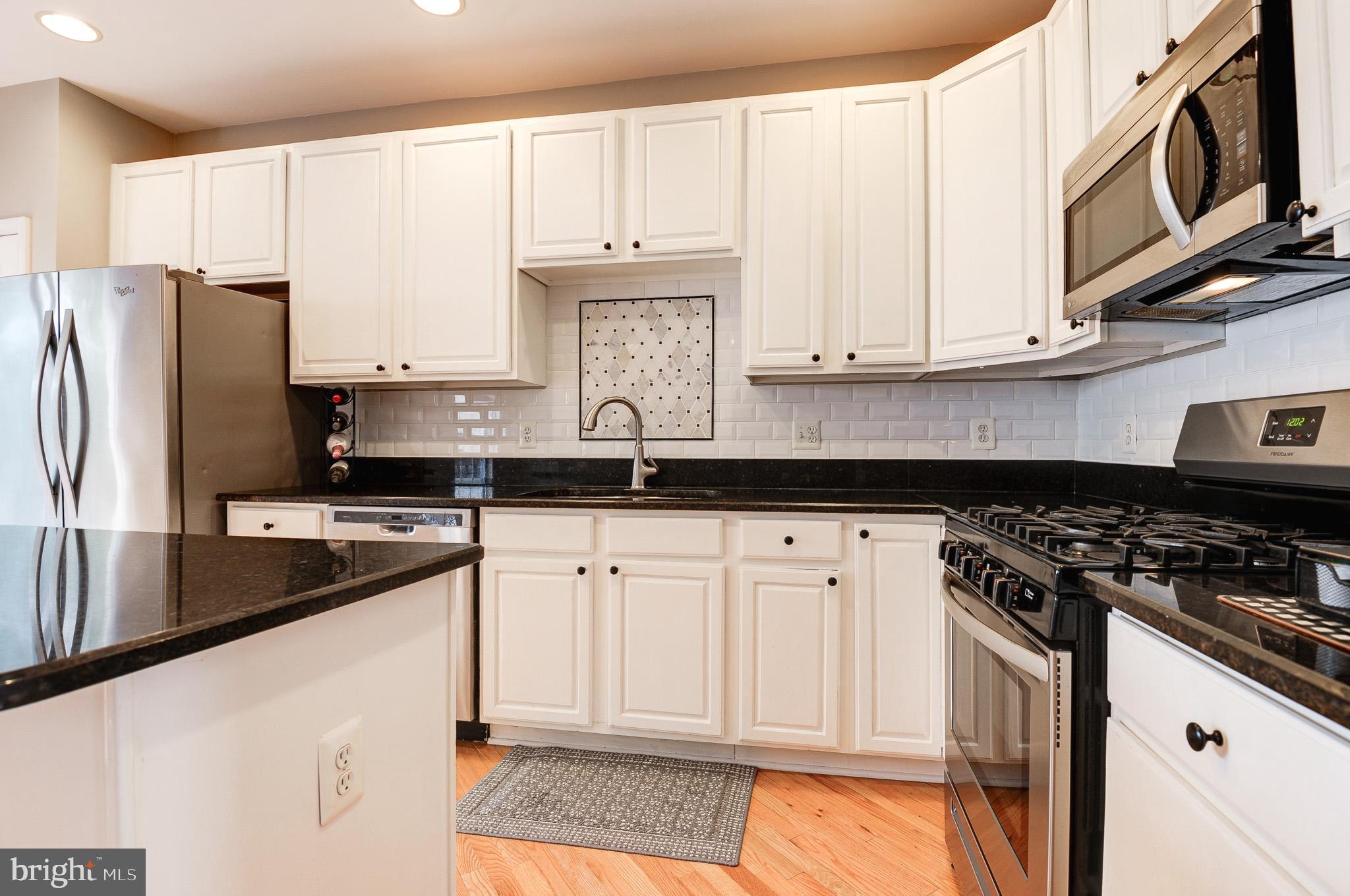 44167 Tippecanoe Terrace Ashburn, VA 20147 - Photo 12 of 56 a kitchen with stainless steel appliances granite countertop a stove a sink and a refrigerator