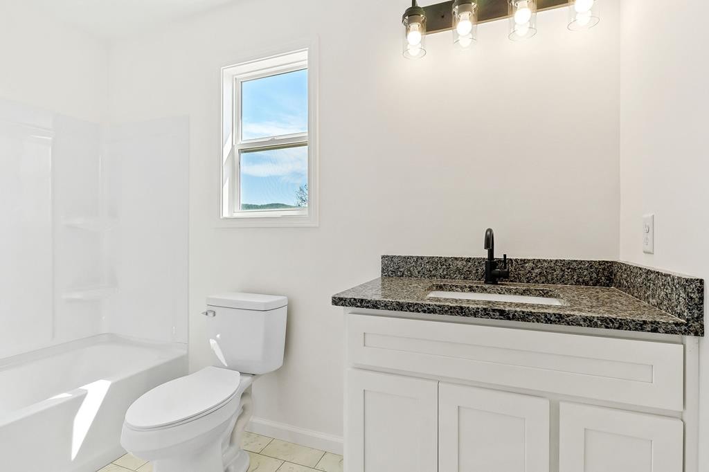 523 Dr I C Morgan Road Spencer, TN 38585 - Photo 13 of 25 a bathroom with a granite countertop toilet sink and mirror