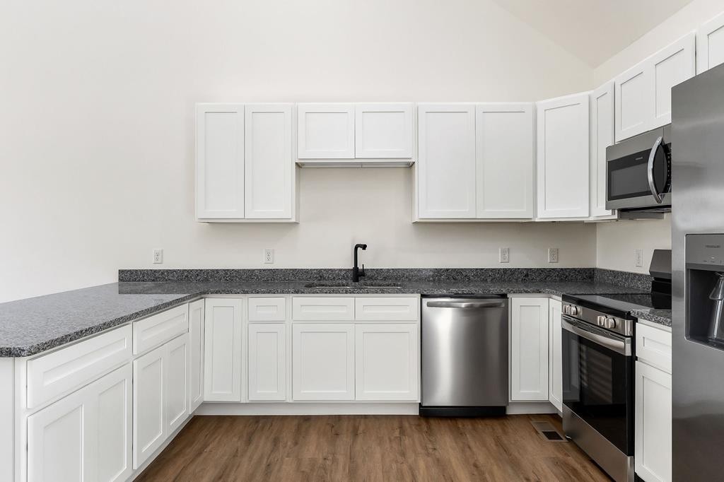 523 Dr I C Morgan Road Spencer, TN 38585 - Photo 8 of 25 a kitchen with granite countertop white cabinets and stainless steel appliances