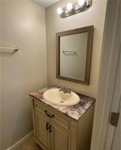 a bathroom with a granite countertop sink a mirror and a toilet