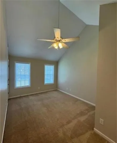 an empty room with windows and ceiling fan
