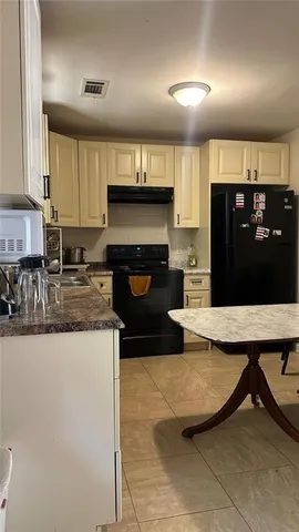 a kitchen with granite countertop a refrigerator and a stove top oven