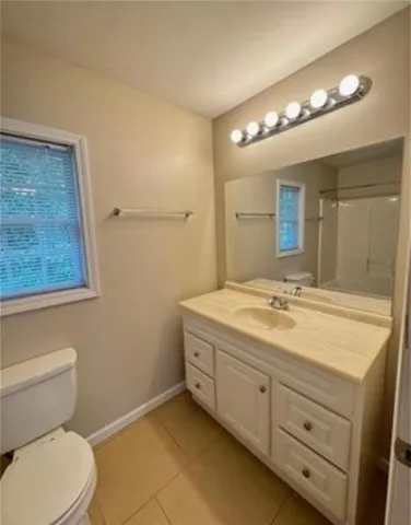 a bathroom with a granite countertop sink mirror vanity and toilet