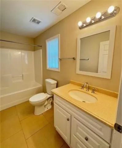 a bathroom with a granite countertop sink a toilet mirror and bathtub