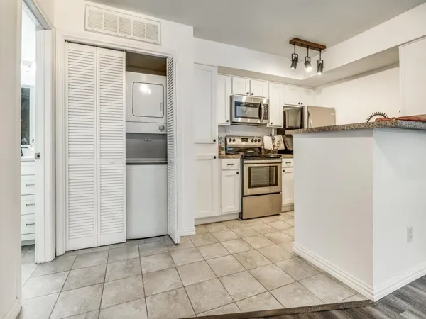 a kitchen with stainless steel appliances granite countertop a refrigerator and a stove top oven